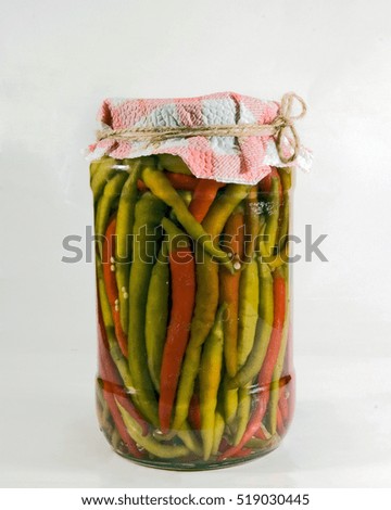 A jar of homemade chili peppers in a solution of vinegar, water and salt.