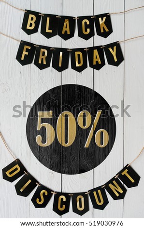 Black Friday fifty percent Discount paper banner garland lettering hanging on white barn wood planks background. Nice vertical holiday flyer.