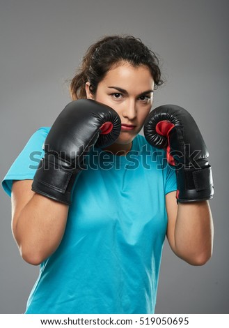 Hispanic female boxer with gloves on in stance