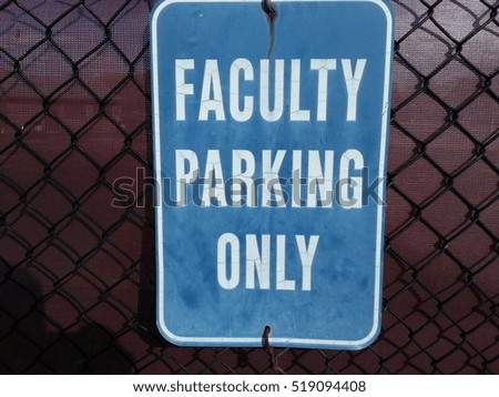 a blue and while faculty parking only sign