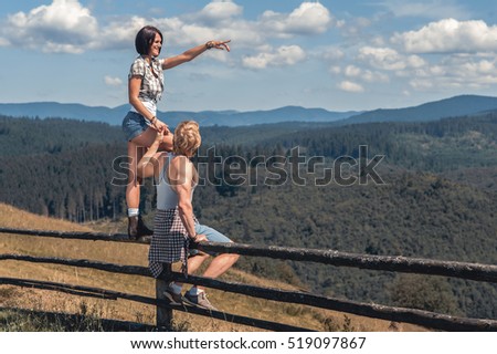 couple of man and woman looking at mountain view and  girl showing the way.  vintage picture