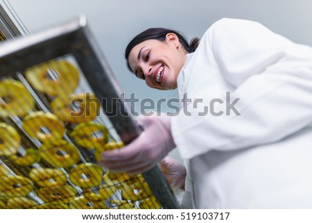 Smiling female food technician working on food dryer dehydrator machine 