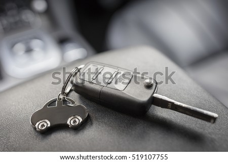 Car shape keyring and remote control key in vehicle interior Royalty-Free Stock Photo #519107755