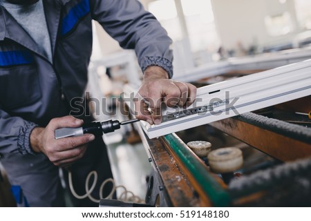 Manual worker assembling PVC doors and windows. Manufacturing jobs. Selective focus. Factory for aluminum and PVC windows and doors production. Royalty-Free Stock Photo #519148180