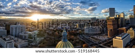 Aerial/Drone panorama of the capital city of Denver, Colorado at sunset.  The Rocky Mountains can be seen on the horizon