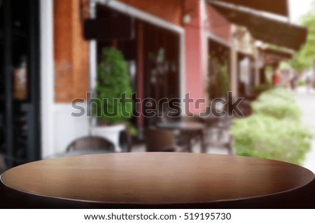 Wood table top on blur background of coffee shop (or restaurant) interior - can be used for display or montage your products.