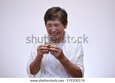 Japanese elderly woman eating sweets with a smile