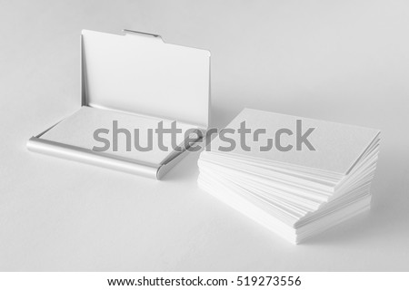 Mockup of blank business cards stack and cardholder at white textured background.