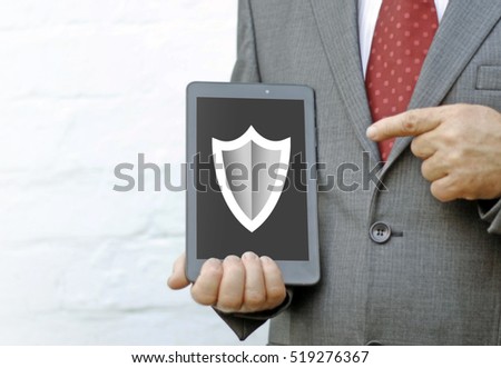 Mobile device tablet pc security concept. Protecting gesture of businessman and symbol of mobile device with shield. Antivirus guard secure app privacy concept: man pointing tablet pc with shield icon