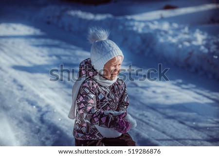 child playing in the snow drifts of