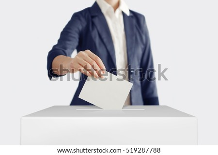 Woman putting a ballot into a voting box. Royalty-Free Stock Photo #519287788