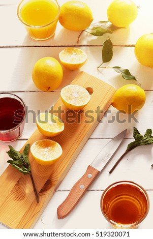 Detox food & drink healthy lifestyle concept: Sweet aromatic fruits juices, orange citrus fruits & green herbs. Lemons, fruits juices & mint. Top view  White wooden background Evening sun toning