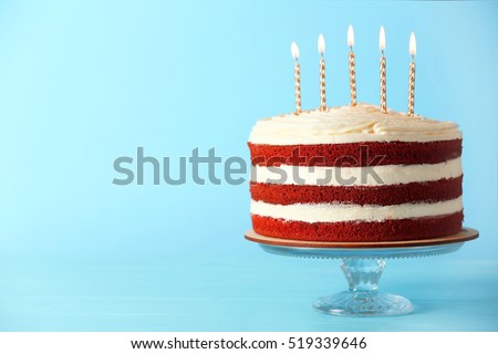 Delicious cake with candles on blue background
