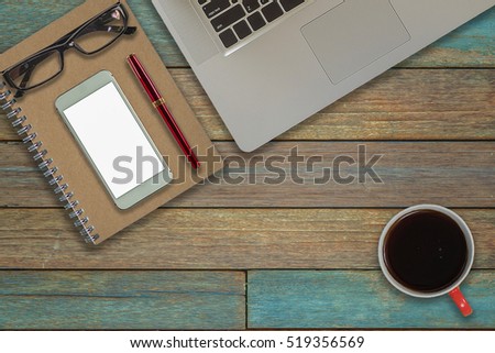 Laptop on Vintage Wooden desktop in modern office with accessories - top view on desk from above.