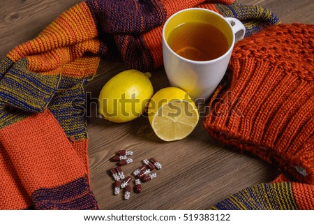 The composition of winter clothing (hat, gloves, scarf), hot tea with lemon and drugs