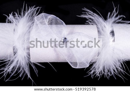 A studio shot of a Christmas Cracker or otherwise known as a Bon Bon.  A cracker consists of a cardboard tube wrapped in a decorated twist of paper with a gift in the central chamber.