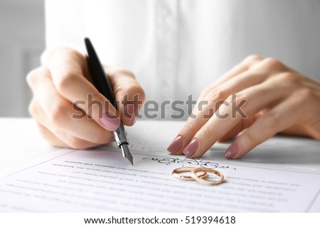 Woman signing marriage contract, closeup Royalty-Free Stock Photo #519394618