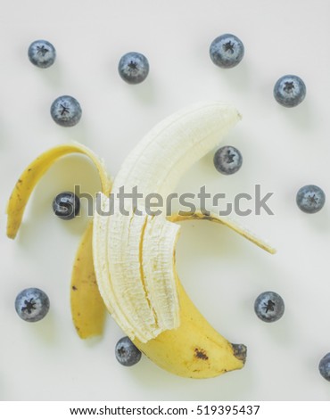 Ripe open banana and blueberries on a white background. Flat lay concept