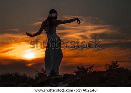 Silhouette of a girl dancing Oriental dance at sunset. Royalty-Free Stock Photo #519402148