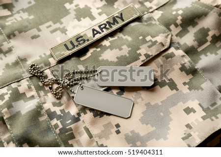Soldier's tokens on camouflage fabric background