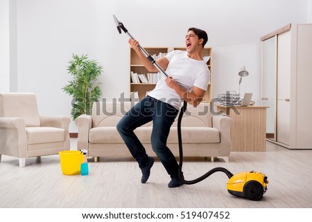 Man cleaning home with vacuum cleaner Royalty-Free Stock Photo #519407452