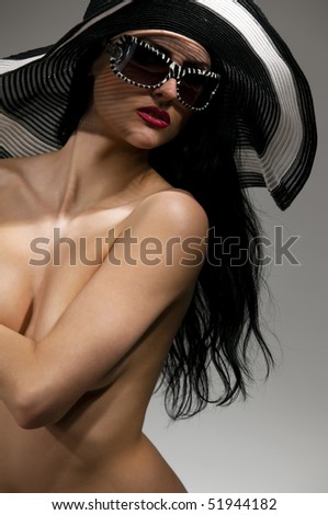 Beautiful model in striped hat topless on the gray  background