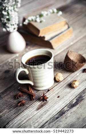 Large Cup of coffee on vintage wooden background. Spring flowers and books.