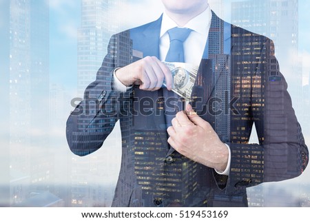 Close up of businessman putting dollar bills in jacket's inner pocket in a city. Toned image. Double exposure. Elements of this image furnished by NASA
