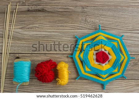 Mandala, star of woolen threads, on wooden boards with space for text