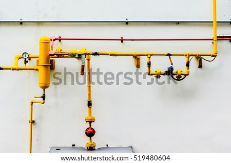 Yellow gas pipe in front of residential building wall, gas pipe in front of residential building wall Royalty-Free Stock Photo #519480604