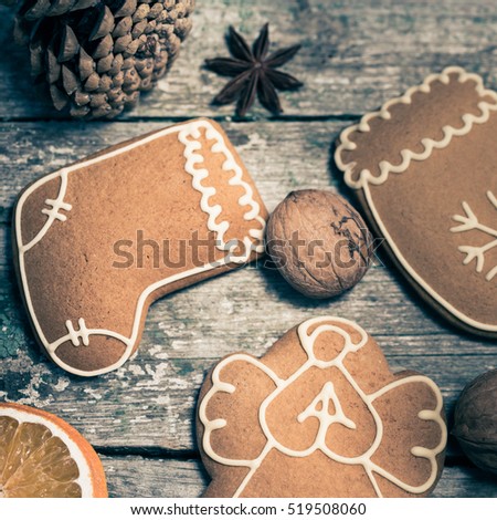 Winter composition with gingerbread cookies, spices, slices of dried citrus fruits and walnuts on an old wooden background. Christmas theme. Top view