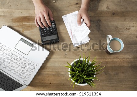 Hands holding bills and paying bills on computer Royalty-Free Stock Photo #519511354