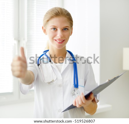 Young doctor showing thumbs up  light background