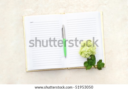 Flower with pen on an open note book.