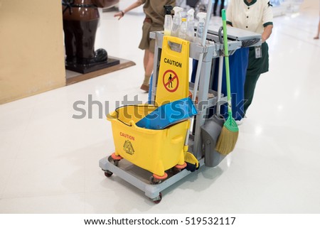 Yellow mop bucket and set of cleaning equipment 
