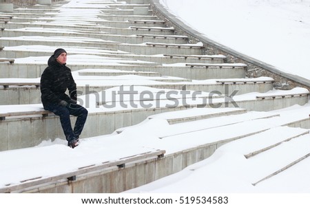 man sit blizzard. look around. alone in winter. snow around