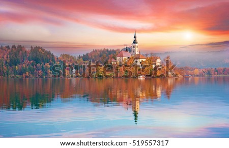 Magical autumn landscape with the island on Lake Bled (Blejsko jezero). Julian Alps, Slovenia, Europe. Attractions. Tourist places of pilgrimage. (Meditation,inner peace, harmony, honeymoon - concept) Royalty-Free Stock Photo #519557317