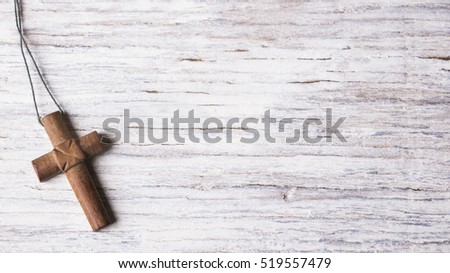 Brown cross on a white wooden background