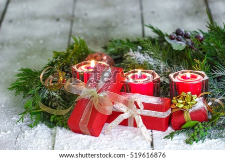 Christmas background with red holiday candles and presents by green Christmas tree garland surrounded by snow background; Christmas background with white copy space