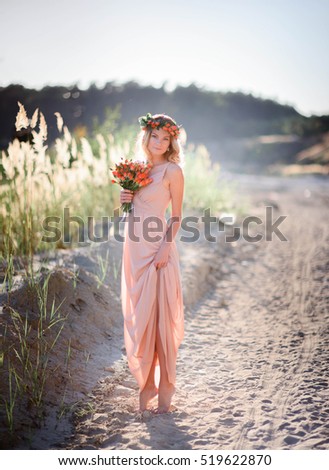 charming and young woman standing alone on sandy path