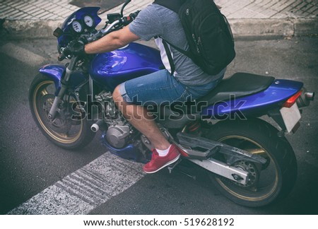 Unrecognizable man on motorcycle in the street.