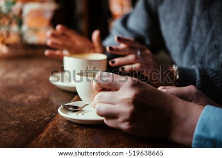 Two women discussing business projects in a cafe while having coffee Royalty-Free Stock Photo #519638665