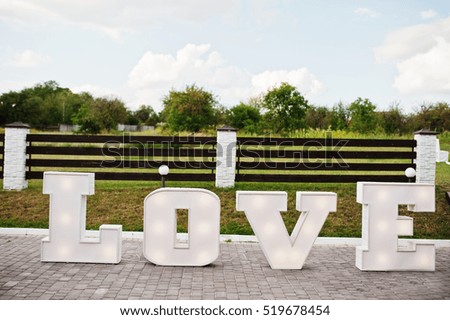 Great big letter word LOVE with light inside at wedding ceremony.