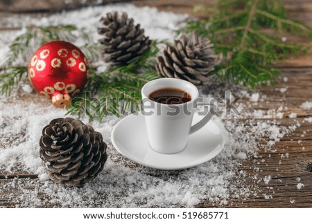 Cup of coffee and christmas toys on wooden table.