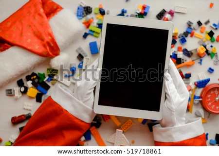 Joyful time and Santa Claus holding mobile tablet computer with blank screen background, Closeup image