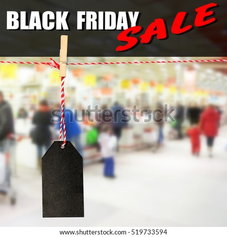 Black friday. Black sale tag against the backdrop of buyers shopping, shallow depth of focus
