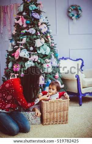 beautiful mother with her sweet little boy sitting near the Christmas tree