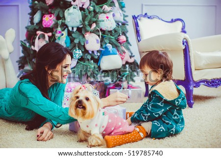 beautiful mother with her sweet little boy sitting near Christmas tree