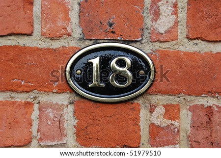 white metallic number (18) hanging a brick wall
