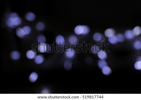 Abstract violet blurred circles for Christmas on black background, glitter light De focused